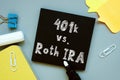 Conceptual hand writing showing 401k vs. Roth IRA