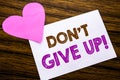 Conceptual hand writing text showing Don t Give Up. Concept for Motivation Determination, written on sticky note paper, wooden woo Royalty Free Stock Photo