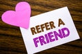 Conceptual hand writing text showing Refer A Friend. Concept for Referral Marketing written on sticky note paper, wooden wood back Royalty Free Stock Photo