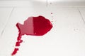 Conceptual image with blood on it resting on tiles on floor. A puddle of dried blood on the tiled bathroom floor