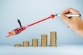 A conceptual image depicting a businessman on a rocket flying over a stack of increasing coins Royalty Free Stock Photo