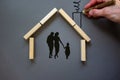 Conceptual image of family values and adoption. House from wooden blocks on beautiful grey background. Male hand draws with black Royalty Free Stock Photo