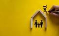 Conceptual image of family values and adoption. House from wooden blocks on beautiful yellow background. Male hand draws with Royalty Free Stock Photo