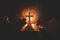 The conceptual image focuses on the candlelight by hand, the person holding the cross on the world, the Bible and blurring in the Royalty Free Stock Photo