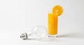 Conceptual image of fresh orange juice and light bulb on white background Royalty Free Stock Photo