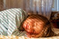 Conceptual image: happiness, carelessness and a sense of absolute safety. Portrait of young child girl wake up and smiling in sun Royalty Free Stock Photo