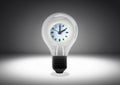 Isolated object shot of a light bulb with a clock inside on a dark background Royalty Free Stock Photo