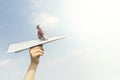 Conceptual image of a little boy who dreams of flying on a paper airplane in the sky Royalty Free Stock Photo