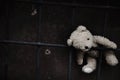 Conceptual image: lost childhood, loneliness, pain and depression. Dirty toy Teddy bear lying down outdoors. Copy space Royalty Free Stock Photo