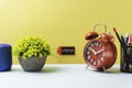 Conceptual image. paper note writing with alarm clock, vase, stationery and portable mini loud speaker against background. copy