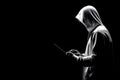 A conceptual image symbolizing hacking and data privacy, featuring a man wearing a black hoodie, holding a laptop Royalty Free Stock Photo