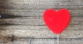 Red Heart on a White Handle in front of Old Grunge Wooden Table