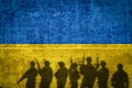 Conceptual image of war between Russia and Ukraine with shadow of soldier against wall with flags