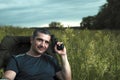 Conceptual image of watching movies in modern technologies, a young man sits in a comfortable chair on the nature under the open