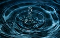 Conceptual image for water purity. Blue water splashÃ¢â¬â¹ed for background. Drops and waves in a glass
