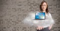 Conceptual image of woman holding cloud and laptop with various application icons Royalty Free Stock Photo