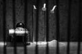 Conceptual jail photo with iron nail escaping behind out of focus bars artistic conversion