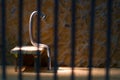 Conceptual jail photo with iron nail sitting behind bars