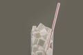 Conceptual macro still life image of refreshment glass full of sugar cubes and straw isolated on white background in glucose addic