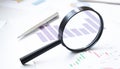 Conceptual Magnifying Glass on Top of Sales Invoice Reports, Emphasizing Scrutinizing Figures Royalty Free Stock Photo