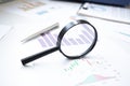 Conceptual Magnifying Glass on Top of Sales Invoice Reports, Emphasizing Scrutinizing Figures Royalty Free Stock Photo