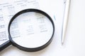 Conceptual Magnifying Glass on Top of Sales Invoice Reports, Emphasizing Scrutinizing Figures Royalty Free Stock Photo