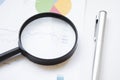 Conceptual Magnifying Glass on Top of Sales Invoice Reports, Emphasizing Scrutinizing Figures Royalty Free Stock Photo