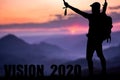 Conceptual message writing showing `vision 2020`. The young mountaineer managed to climb to the top and achieve his goal.