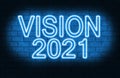 A conceptual message written by the blue neon light on the wall shows `vision 2021`. Business motivation, inspiration concepts ide