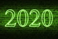 A conceptual message written by the green neon light on the wall shows `2020`. Business motivation, inspiration concepts ideas.