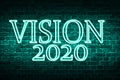 A conceptual message written by the neon light on the wall shows `vision 2020`. Business motivation, inspiration concepts ideas.