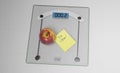 Conceptual and modern still life delicious apple and yellow posit note text saying eat clean stuck on bathroom scale in weight