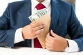 Conceptual photo of bribed man putting money in the suit pocket Royalty Free Stock Photo