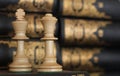 Conceptual photo. Chess pieces on a book in a library with books on the bookshelf background. Chess piece photography. Remote off