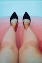 Conceptual photo. Female feet in black leather shoes. Take a shower with your clothes on Royalty Free Stock Photo