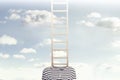 A conceptual photo with a ladder coming out of a person`s body and climbing towards a cloudy sky