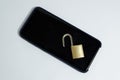 Conceptual photo security on mobile phones. A open padlock on a cell phone on a white background Royalty Free Stock Photo