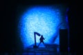 Conceptual Photo, Silhouette Bassist or Guitarist in Action, at Fake Stage, Blue Lighting Royalty Free Stock Photo