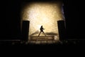 Conceptual Photo, Silhouette Bassist or Guitarist in Action, at Fake Stage, Yellow Lighting Royalty Free Stock Photo