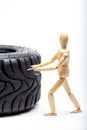 The concept of the workshop tire fitting. Miniature mechanic repairing dusty car wheel, close up Royalty Free Stock Photo