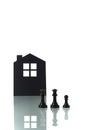 Chess pieces with silhouette of a house in the background Royalty Free Stock Photo