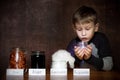 European appearance boy. In jars next to him joy, anger, laziness. In the hands of a child a jar of happiness Royalty Free Stock Photo