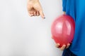 Conceptual photography. The man holds a red ball near his belly, which symbolizes bloating and flatulence. Then he brings a needle