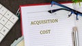 A conceptual phrase on the topic of ACQUISITION COST business. Business concept Royalty Free Stock Photo