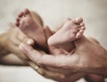 Conceptual picture of parents golding a baby's feet