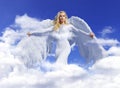 Conceptual portrait of a blond angel flying up to the sky