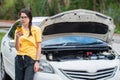 Portrait of young woman trying to call someone to help her after her car breakdown on the road. Royalty Free Stock Photo