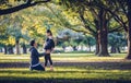 Portrait of lovely couple outdoors. Women pregnancy with her husband kneeling and kiss on her belly.