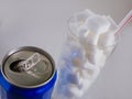 Conceptual still life image of glass with straw full sugar cubes and soda refresh drink in unhealthy nutrition sugar addiction an