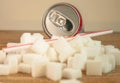 Conceptual still life image of pile of sugar cubes and soda refresh drink with straw in unhealthy nutrition sugar addiction and re